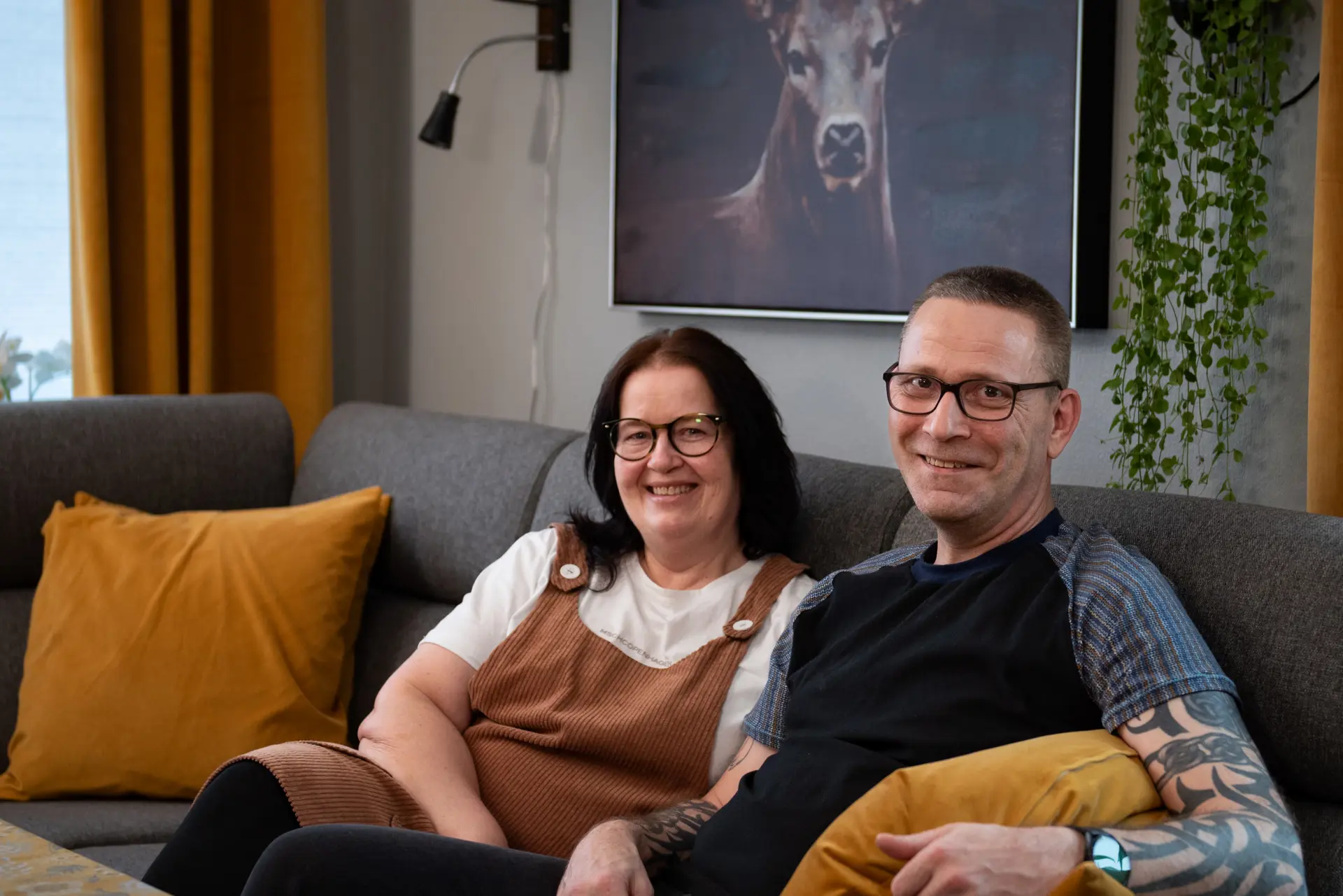 To smilende mennesker i en sofa